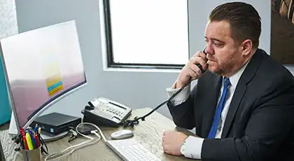 Abogados de Arash Law en un juicio, hablando por teléfono en su escritorio