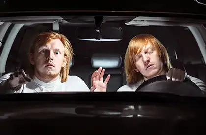 Conductor somnoliento y pasajero dentro de un auto