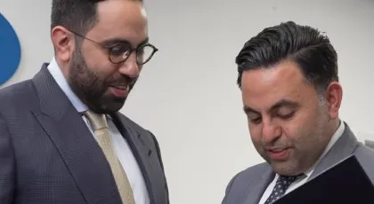 Dos abogados de AK revisan los documentos relacionados con un caso de accidente de camión, centrándose en la compleja cobertura del seguro en comparación con los accidentes de coche.