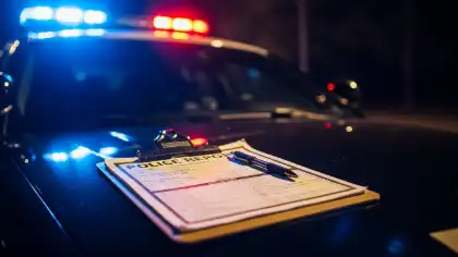 Informe policial sobre el capó de un coche patrulla tras un accidente de tráfico