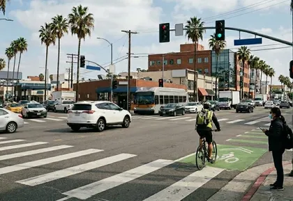 Intersección de una ciudad californiana con coches, peatones y ciclistas que ilustra el aumento de las muertes por accidentes de tráfico y la preocupación por la seguridad de Visión Cero.