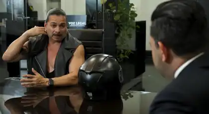 Motociclista hablando con un abogado durante una consulta gratuita sobre una reclamación por accidente