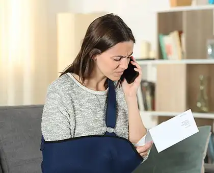 Mujer lesionada mirando su factura médica