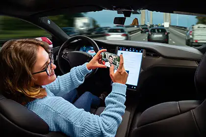 Mujer usando el teléfono mientras conduce en-modo piloto automático