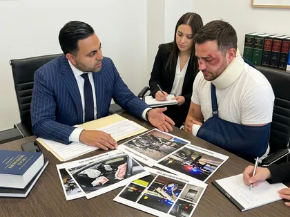 Orange County DUI accident consultation between attorney and injured client reviewing crash evidence photos and reports in office