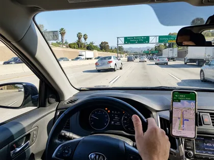 Orange County freeway driving view from inside car with GPS navigation on smartphone and heavy traffic ahead