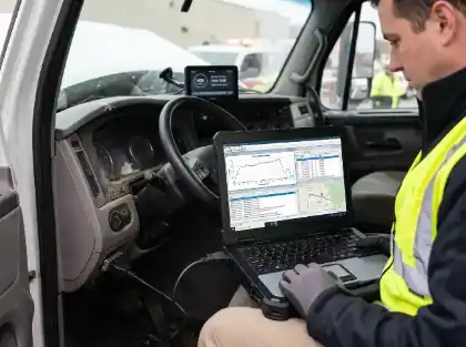 Un trabajador comprueba los datos de un vehículo en un ordenador portátil dentro de un camión