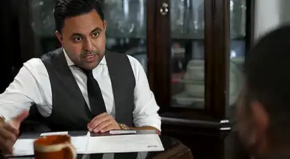 Abogado AK hablando con un cliente durante una consulta inicial en una mesa
