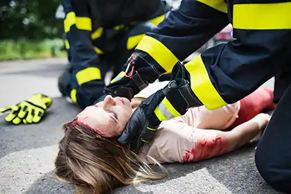 bomberos irreconocibles ayudando a un joven herido