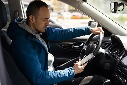 un conductor de Uber que utiliza la aplicación mientras conduce