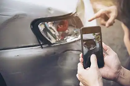 un hombre que está haciendo una foto como prueba de un accidente de tráfico