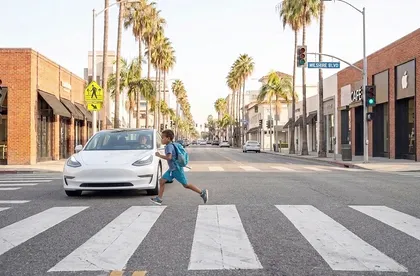 Child pedestrian crossing in front of a car at a marked crosswalk