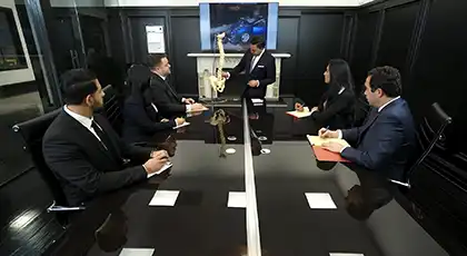 Los abogados de Arash Law analizan un caso con ayuda de un modelo de columna vertebral y una foto del accidente