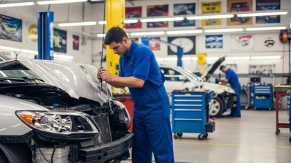 Mecánico inspeccionando componentes del motor durante la reparación de un vehículo en un taller de coches
