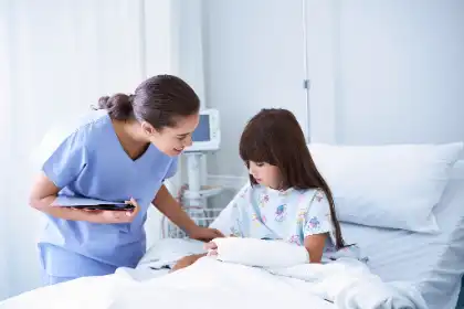 Nurse comforting a girl with a casted arm