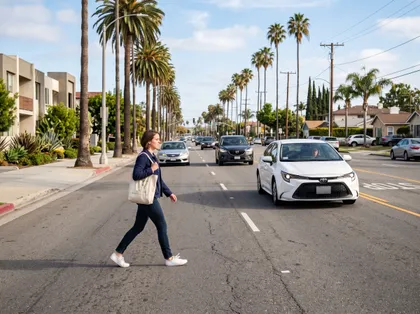 Pedestrian jaywalking across a busy street with oncoming vehicles