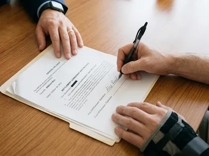 Personal injury settlement process showing a client reviewing and signing legal documents with attorney assistance