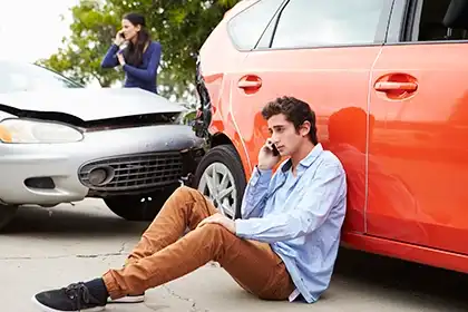 Un conductor adolescente junto a su coche tras un accidente