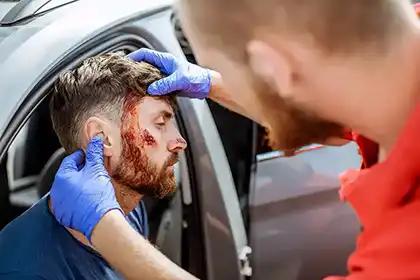 Un miembro del equipo de emergencia evaluando las lesiones tras un accidente