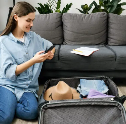 Un viajero se prepara para un viaje por carretera seguro este verano, haciendo las maletas con lo imprescindible y planificándolo todo con antelación