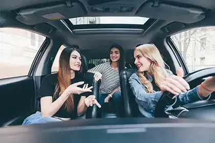 Una conductora adolescente que habla con sus amigos mientras conduce