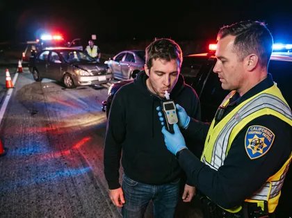 Agente de policía realizando una prueba de alcoholemia tras un accidente