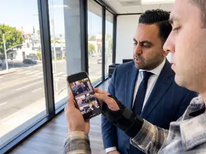 Un cliente le enseña a un abogado las fotos de un accidente de coche