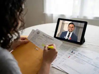 Una víctima de un accidente de carro revisa el informe del accidente de tráfico durante una consulta virtual con un abogado especializado en lesiones personales