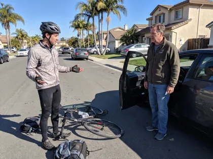 Accidente de bicicleta entre un ciclista y un conductor, con una bicicleta caída junto a un carro