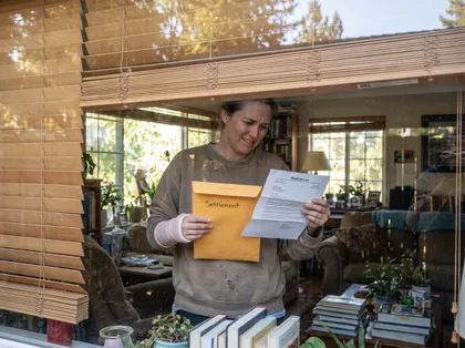 Injured claimant with a wrapped wrist reviews medical lien documents and settlement paperwork after a personal injury case