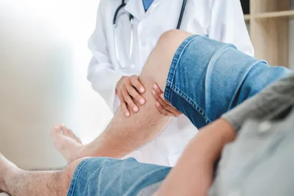Médico examinando una lesión de rodilla tras un accidente por resbalón y caída