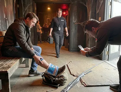 Haunted house injury victim documenting a foot injury while staff investigate the accident scene