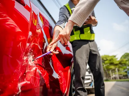 Perito de seguros que inspecciona los daños de un vehículo tras un accidente de carro con un coche de alquiler