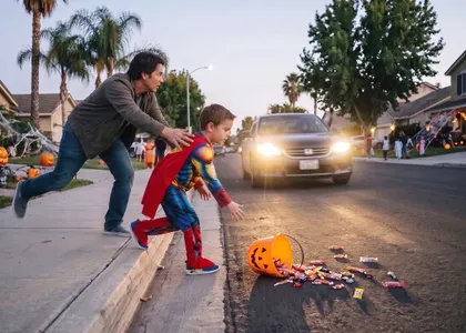 Un padre de California protege a su hijo, que estaba pidiendo caramelos, de un carro que se acercaba la noche de Halloween