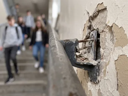 Unsafe school railing injury risk illustrated by a deteriorating stairwell handrail